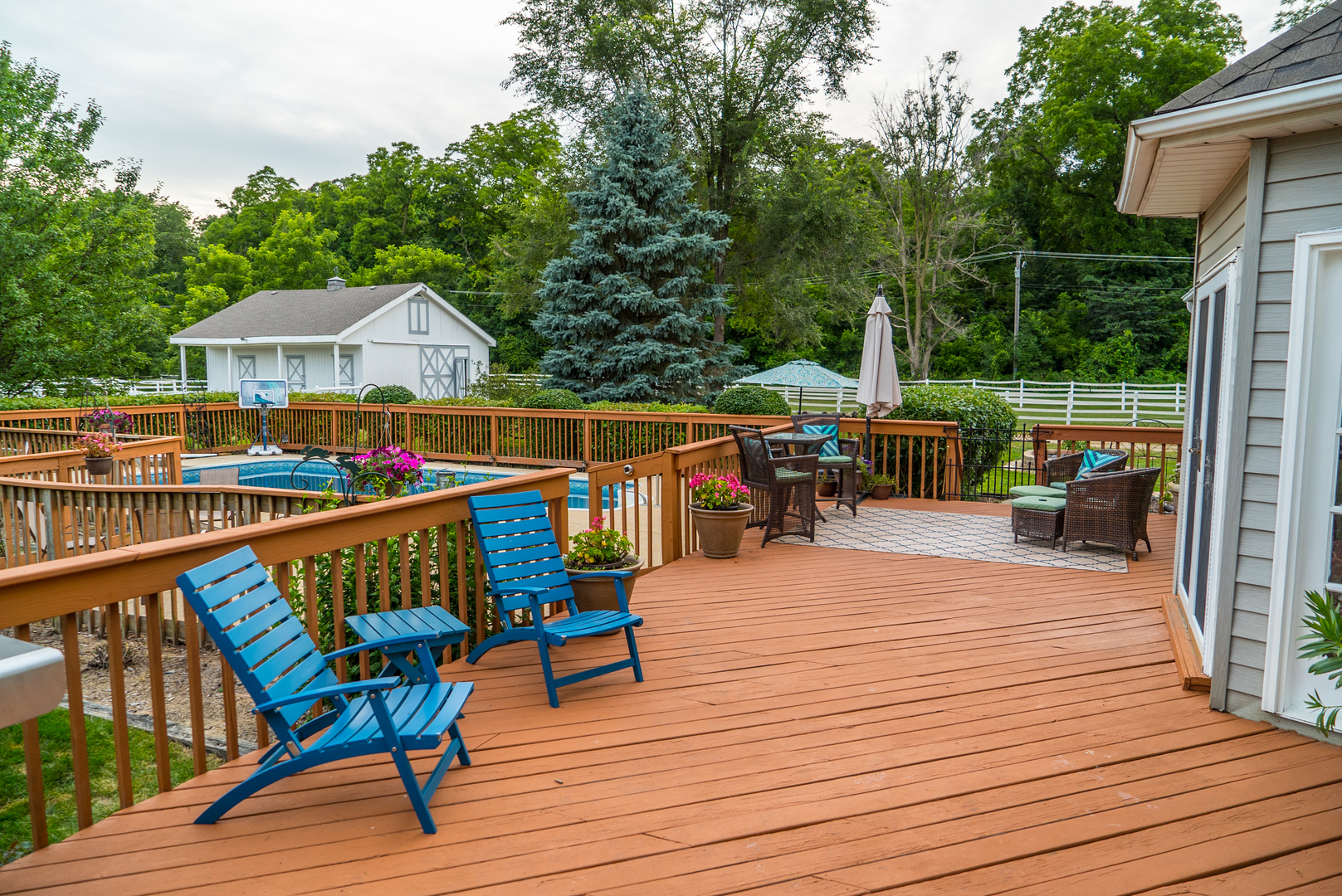 5N884 Dunham Trails Road Wayne, IL 60184 - Photo 17 of 26 a view of a roof deck with table and chairs under an umbrella with wooden floor
