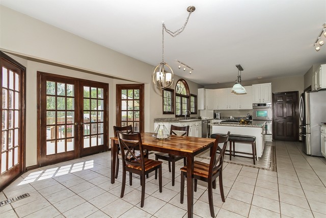 5N884 Dunham Trails Road Wayne, IL 60184 - Photo 8 of 26 a kitchen with a dining table chairs and cabinets