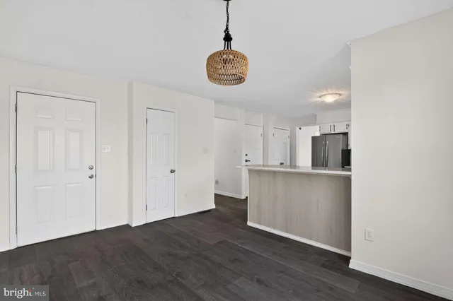 an empty room with wooden floor cabinet and windows