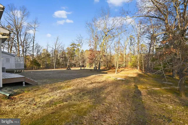 a view of a dining room and livingroom with furniture wooden floor a chandelier