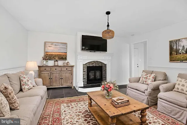 a view of an empty room with kitchen and window