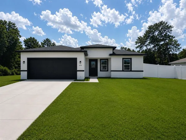 a front view of a house with garage and yard