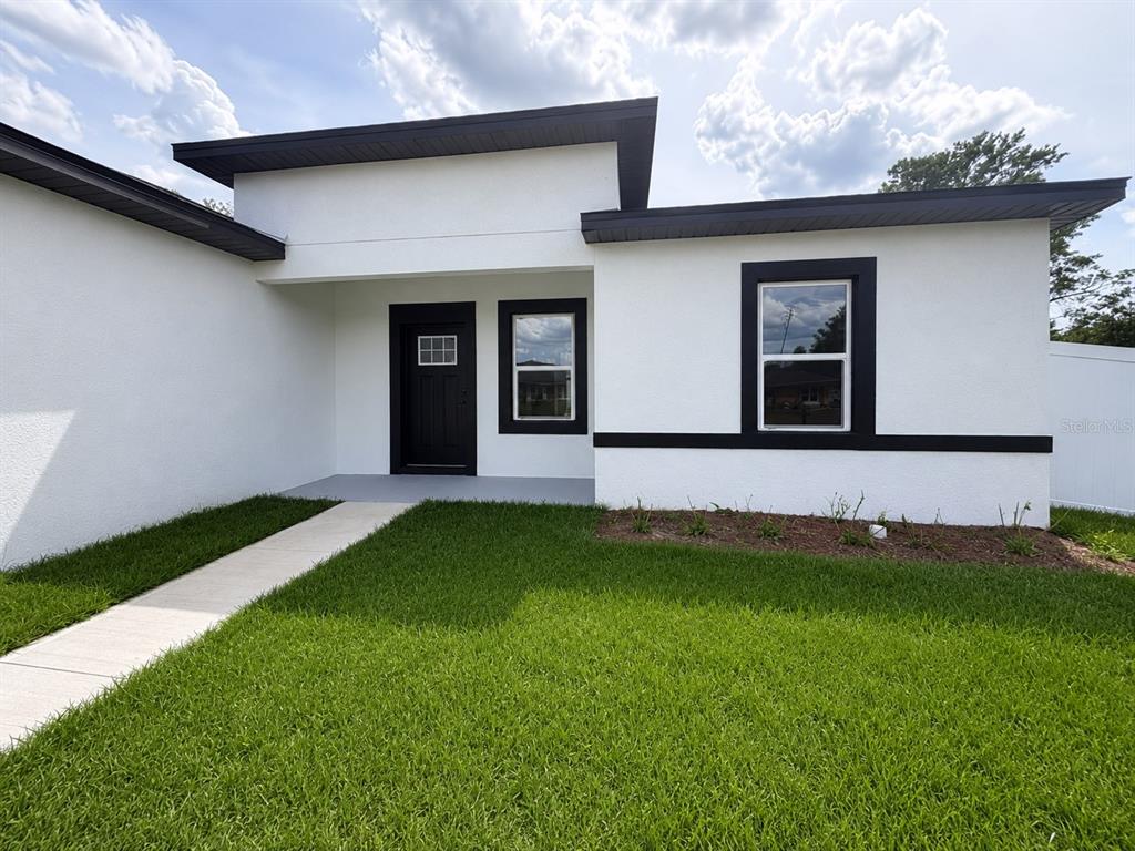 16252 Southwest 27th Terrace Road Ocala, FL 34473 - Photo 2 of 15 a front view of a house with a garden