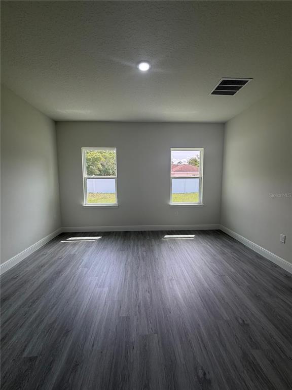 16252 Southwest 27th Terrace Road Ocala, FL 34473 - Photo 4 of 15 an empty room with wooden floor and windows