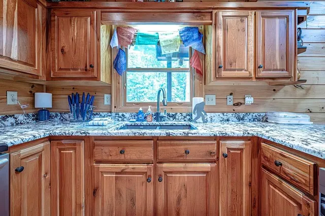 a kitchen with granite countertop a sink and a window