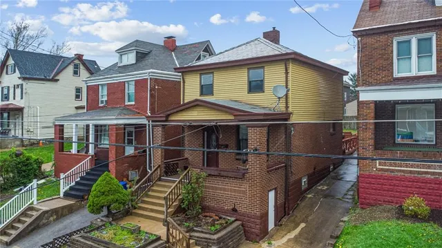 a view of a white house with large windows and a small yard