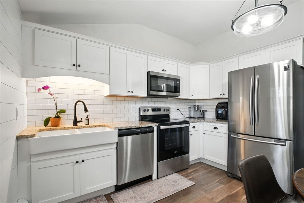 19 Harbour Road Springfield, MA 01118 - Photo 13 of 28 a kitchen with cabinets stainless steel appliances a sink and wooden floor