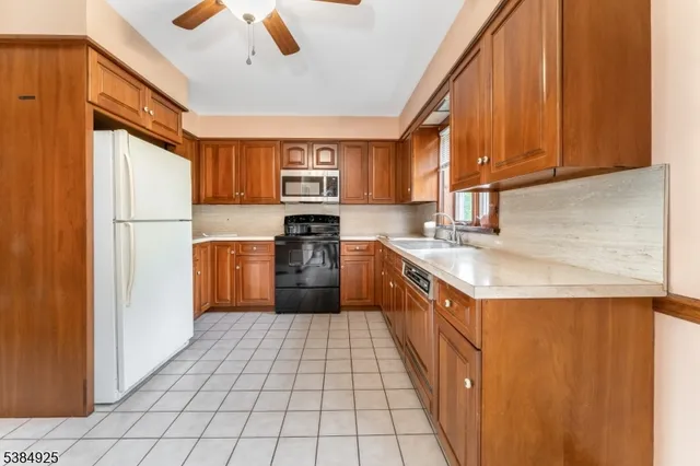a kitchen with a sink a stove top oven a refrigerator and cabinets