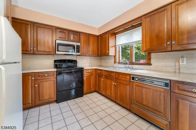 a kitchen with stainless steel appliances granite countertop a stove sink microwave and window