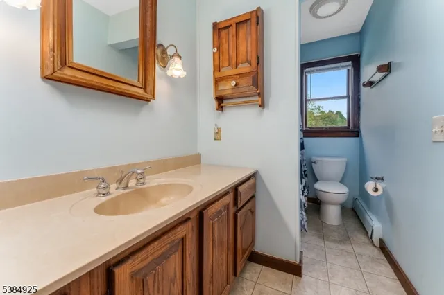 a bathroom with a granite countertop toilet sink and mirror