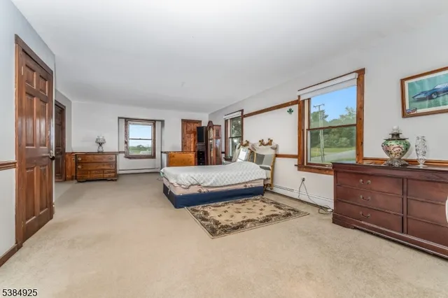 a bedroom with a bed window and dresser