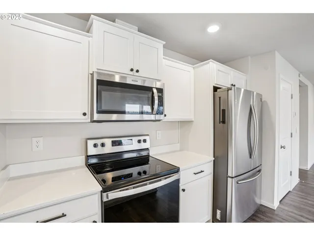 a kitchen with stainless steel appliances a refrigerator stove and microwave