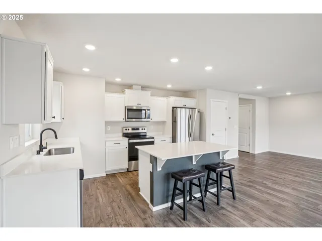 a kitchen with stainless steel appliances kitchen island granite countertop a sink and cabinets
