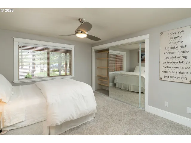 a spacious bedroom with a bed and a large mirror
