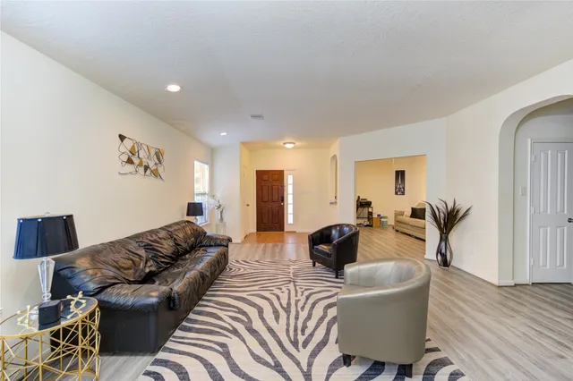a living room with furniture and a wooden floor