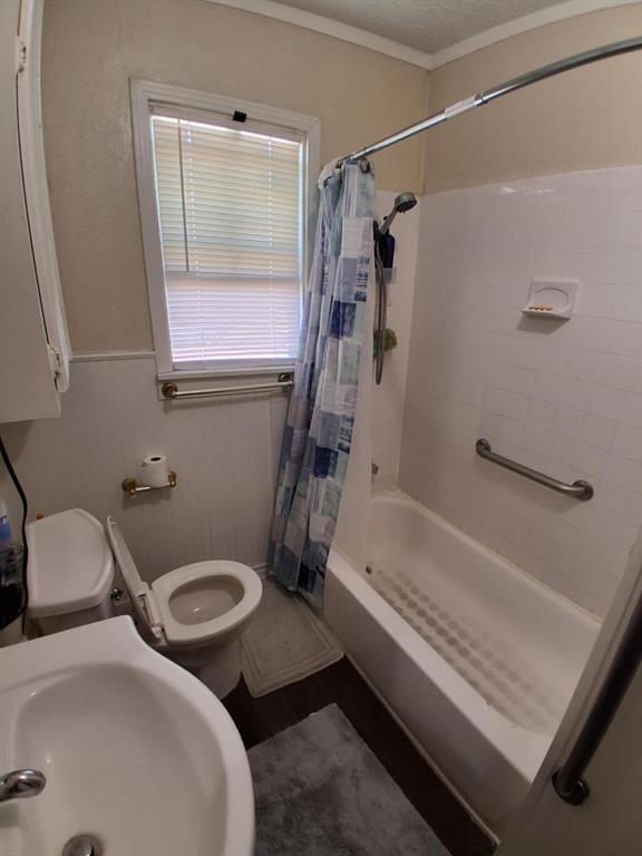 1015 East Morphy Street Fort Worth, TX 76104 - Photo 10 of 23 Bathroom featuring shower / bathtub combination with curtain and a textured ceiling