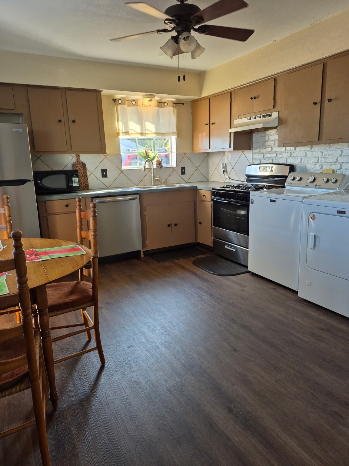 2102 North Pearland Avenue Pearland, TX 77581 - Photo 11 of 29 a kitchen with stainless steel appliances a sink a stove a refrigerator cabinets dining table and chairs