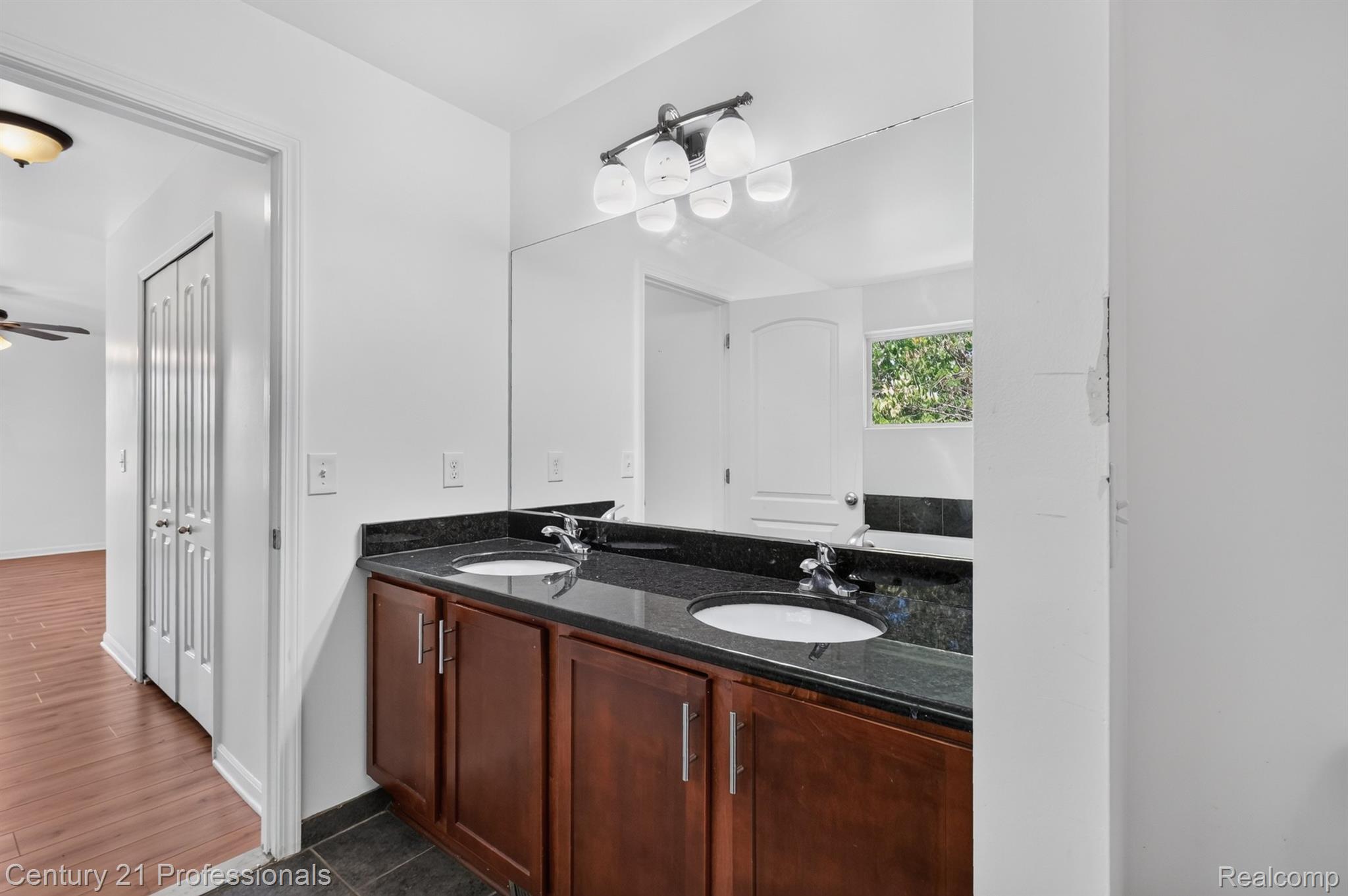 2042 Decker Road Walled Lake, MI 48390 - Photo 25 of 48 Dual vanity with dark wood-finish cabinetry, integrated sinks, and a polished dark countertop