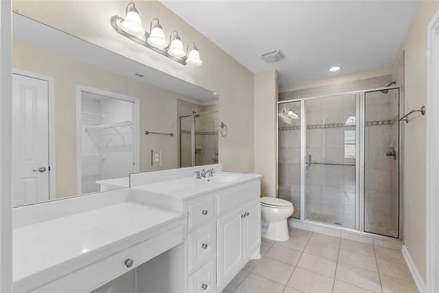 a spacious bathroom with a shower sink and mirror
