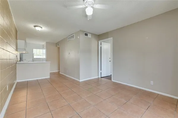 an empty room with fan and windows