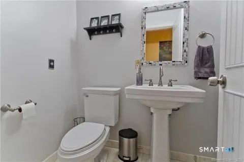 7 Riverview Street Enfield, CT 06082 - Photo 23 of 29 a bathroom with a sink a toilet and mirror