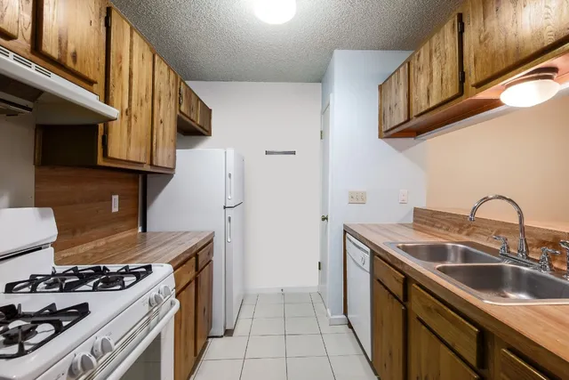 a kitchen with a sink stove top oven and cabinets