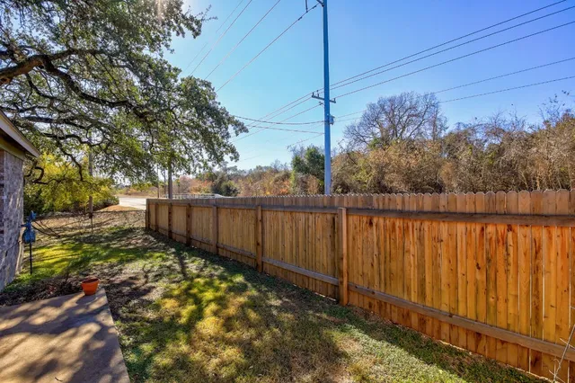 a view of a backyard with wooden fence