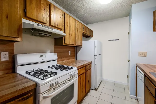 a kitchen with stainless steel appliances granite countertop a stove and a refrigerator