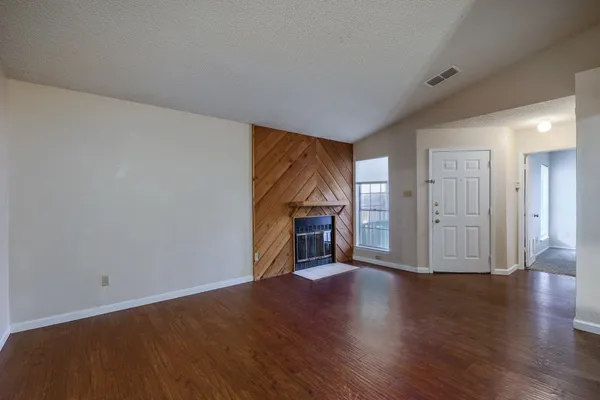 a view of a livingroom with wooden floor and a fireplace