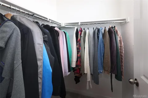 a view of walk in closet with clothes