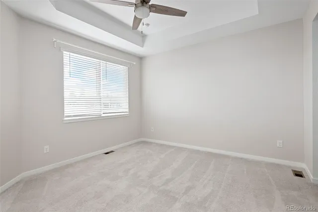 an empty room with a ceiling fan and window