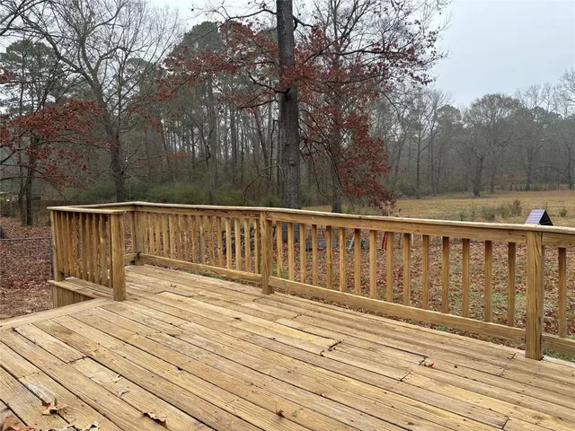 a view of deck with wooden floor and trees