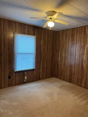 en empty room with windows and fan