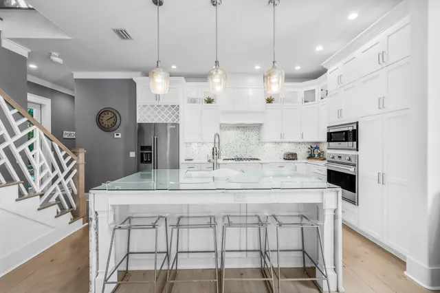 a kitchen with kitchen island granite countertop a sink a center island and stainless steel appliances