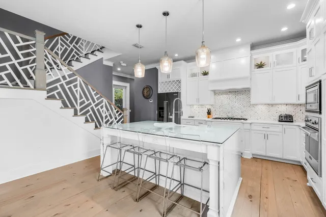 a kitchen with stainless steel appliances granite countertop a sink a stove and a refrigerator