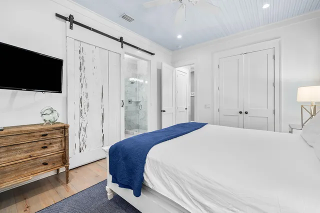 a spacious bedroom with a bed and a flat screen tv