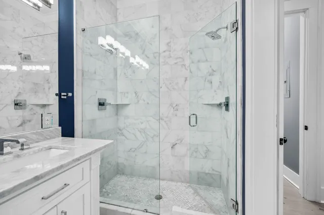 a bathroom with a granite countertop shower a mirror and a sink