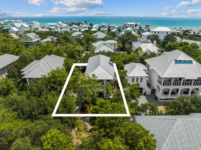 an aerial view of multiple houses with a yard