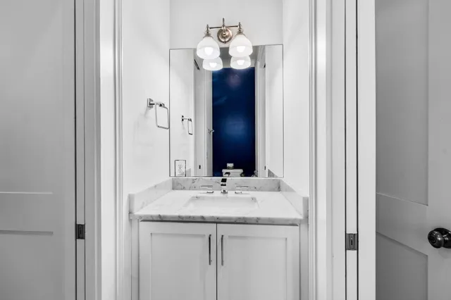 a bathroom with a granite countertop sink and a mirror