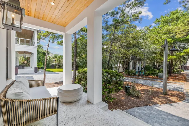 a view of a patio with couches chairs and wooden floor
