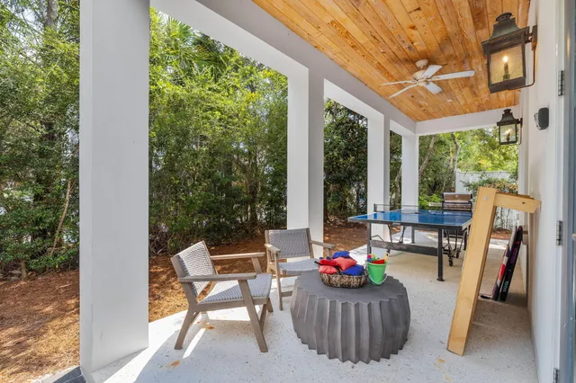 a view of a patio with a table chairs and a floor to ceiling window