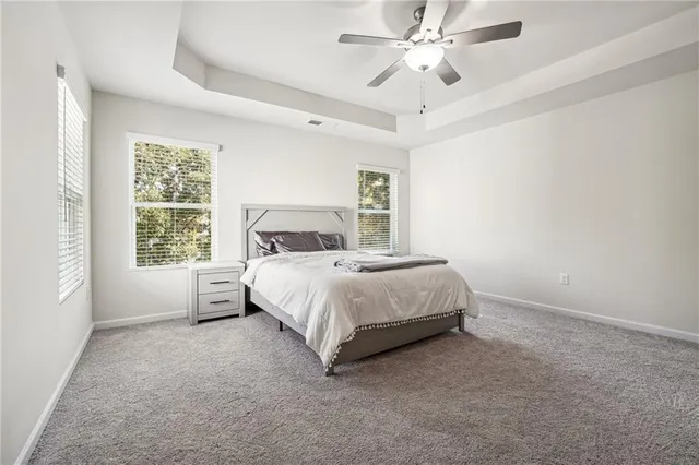 a bedroom with a large bed and a chandelier fan