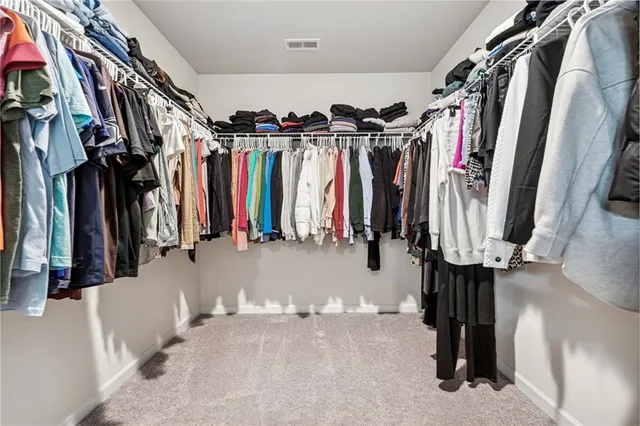 a view of walk in closet with clothes