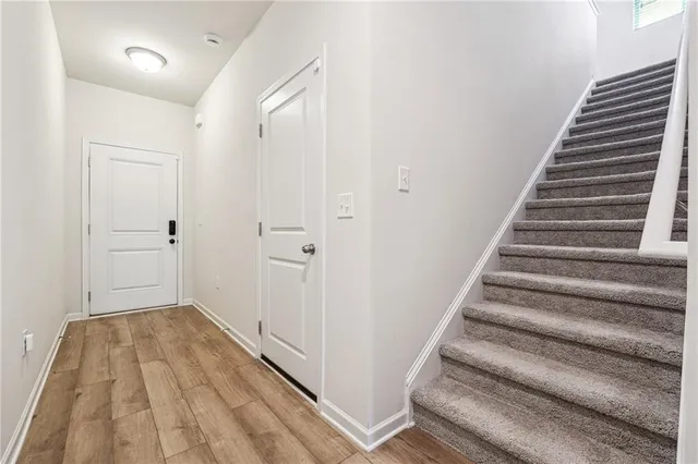 a view of a hallway with wooden floor and entryway