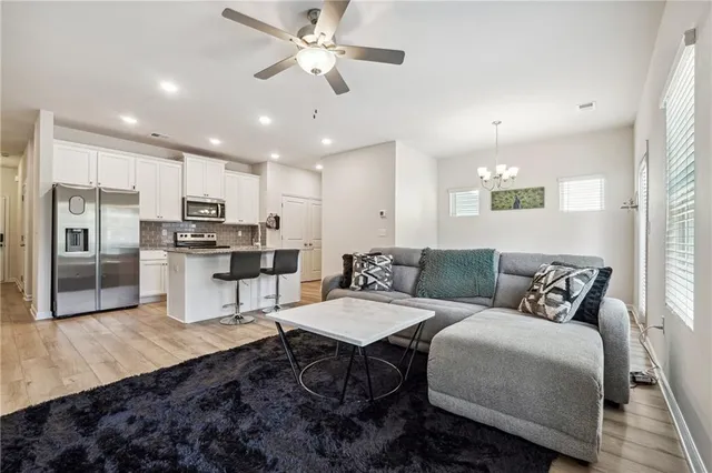 a living room with stainless steel appliances kitchen island granite countertop furniture and a view of kitchen