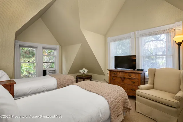a bedroom with two beds and a television