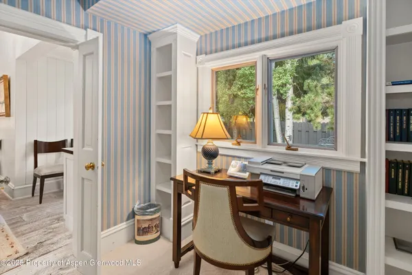 a view of a workspace with furniture and a window