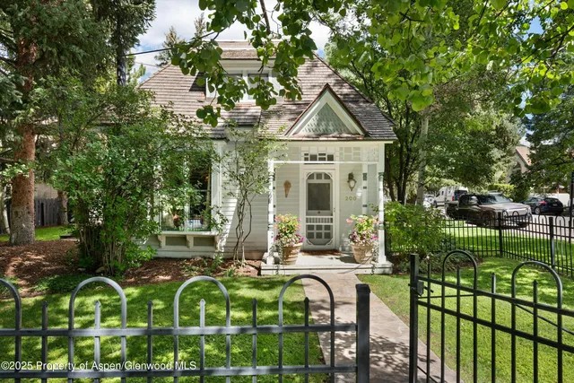 a view of a house with large trees and plants