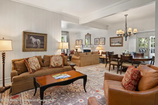 a living room with furniture a dining table and a chandelier