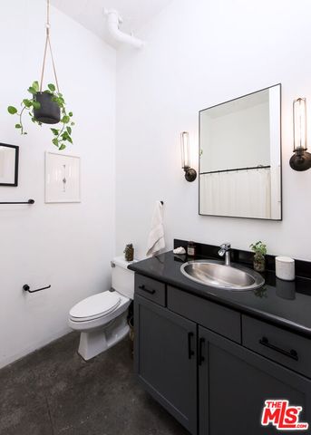 a bathroom with a granite countertop toilet sink and mirror